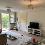 Half-painted modern living room showing before and after contrast