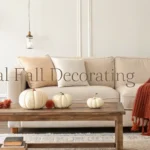Cozy neutral fall living room with beige sofa, pumpkins, and soft lighting.